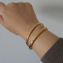 Load image into Gallery viewer, Hand wearing multiple gold bracelets waterproof and tarnish free